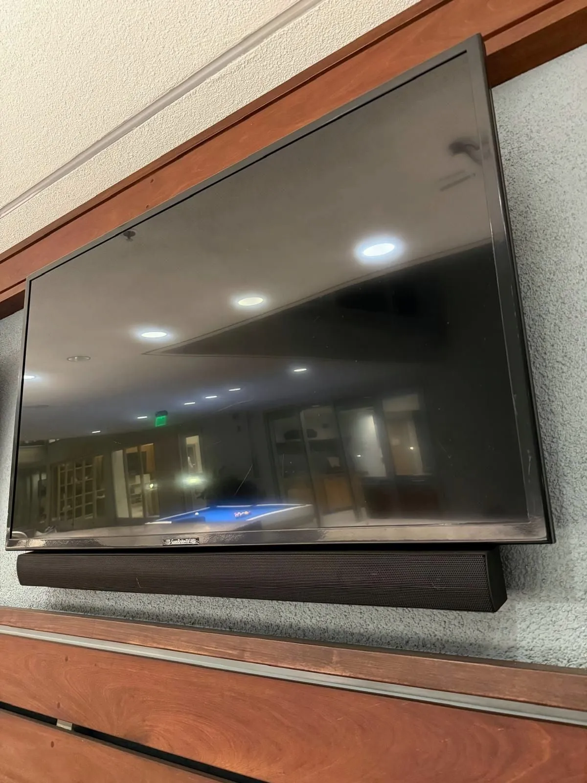 Wall-mounted TV with a matching soundbar fixed underneath